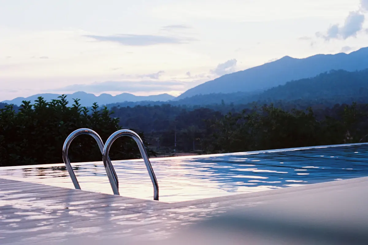 Pool edge with a metal entry rail and a mountain view