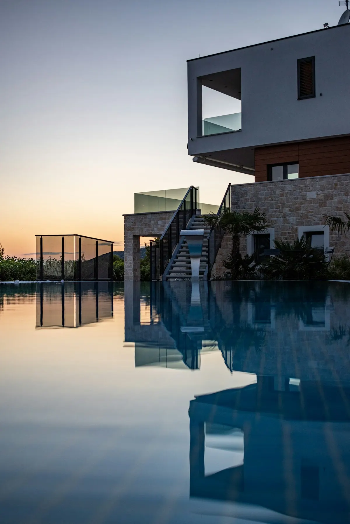 Pool surface reflecting a lit house exterior