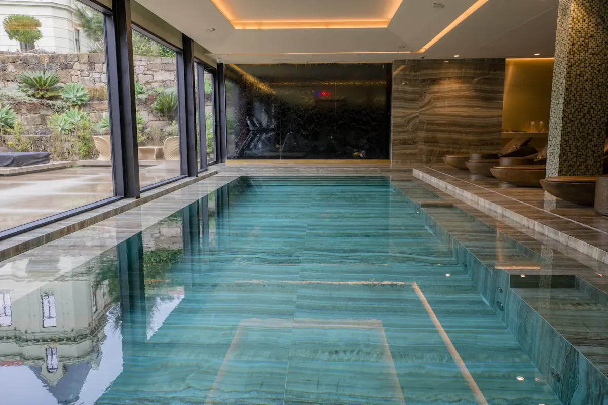 Indoor pool alongside floor-to-ceiling glazing